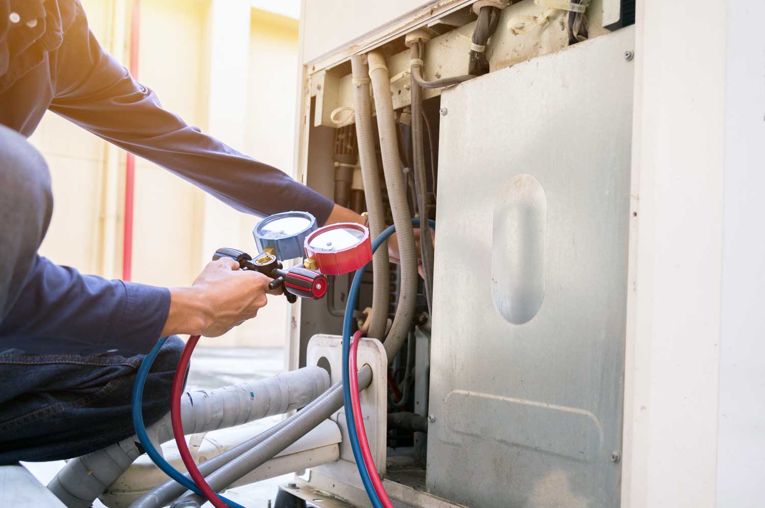 person repairing air conditioning systems outside a home